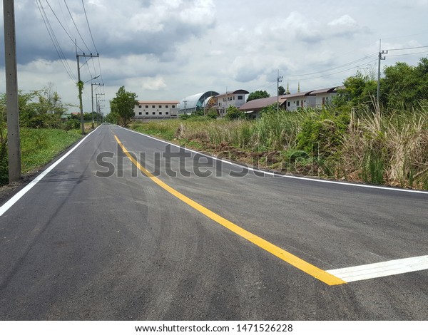 The yellow line divides the lane on\
the road. The cement road has a yellow lane dividing line to reduce\
accidents. The structure of the road made of\
cement.