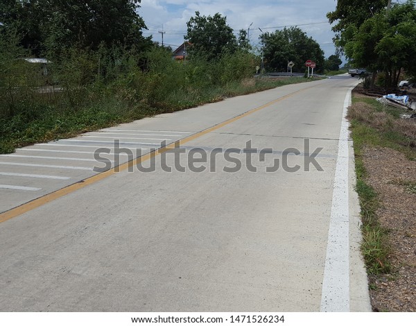 The yellow line divides the lane on\
the road. The cement road has a yellow lane dividing line to reduce\
accidents. The structure of the road made of\
cement.
