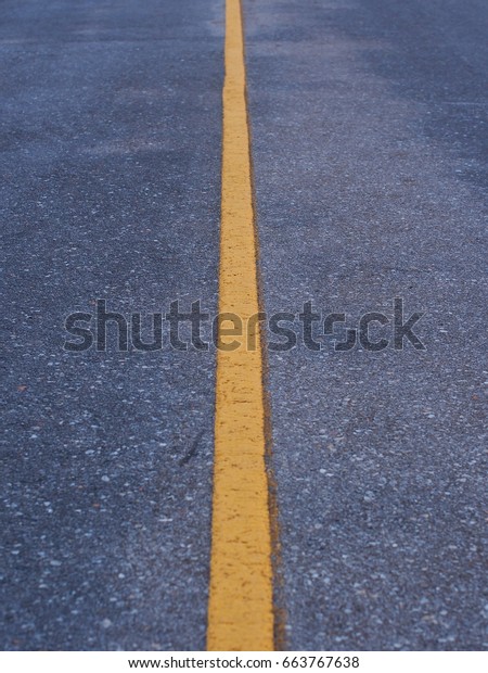 Yellow line in the middle of the road symbol,Soft\
focus and blur back\
ground.