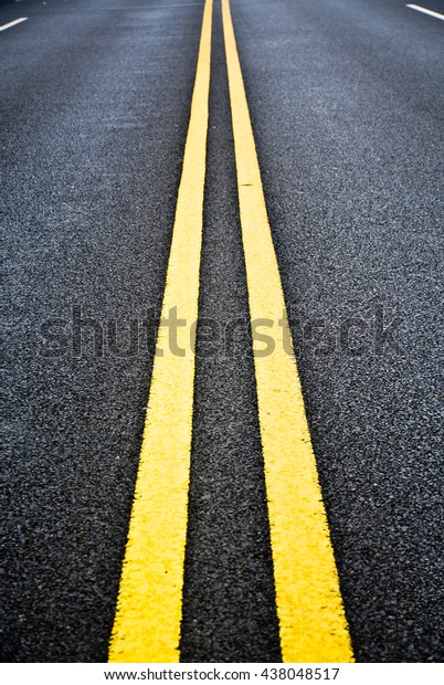 Yellow line on\
asphalt.
