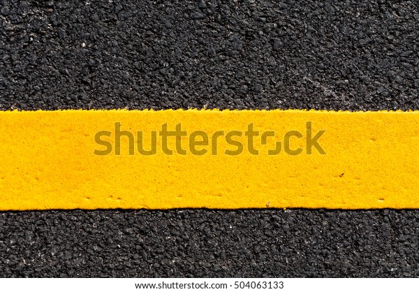 Yellow line on new asphalt detail,Street with\
yellow line texture