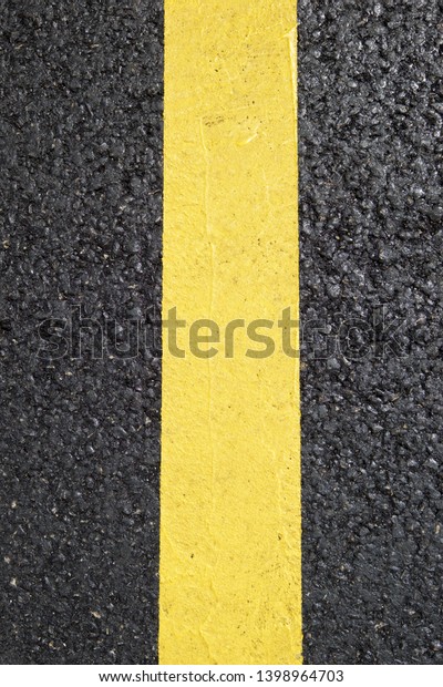 Yellow line painted on the\
asphalt.