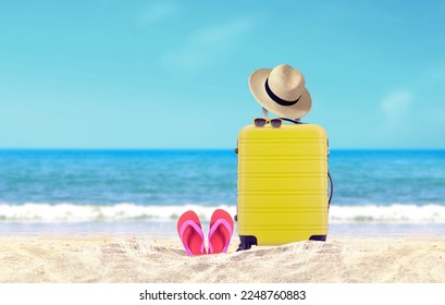 Yellow luggage with hat and red flip-flop on sandy beach under blue sky background. - Shutterstock ID 2248760883