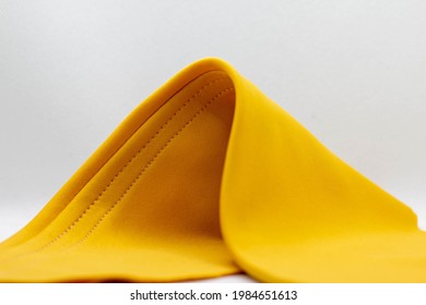 A Yellow Lycra Fabric Folds In White Background.