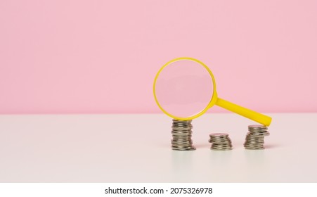 Yellow Magnifier And White Coins On The Table. Income Growth Concept, High Percentage Of Investment. Search For New Sources Of Income, Subsidy