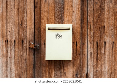 Yellow mailbox on the wooden wall.Vintage style mailbox on the wooden door.Post box hanging on the wooden door. - Shutterstock ID 2258025041