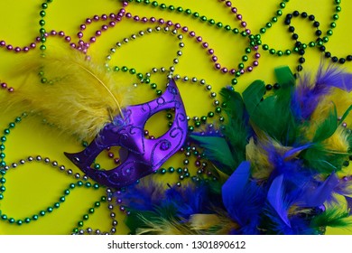 Yellow Mardi Gras Background With Mask, Beads And Feather Boa.