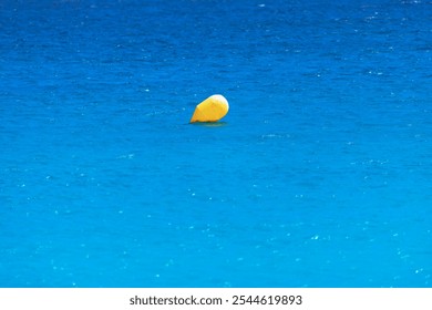 Yellow marker buoy floating in the sea. Solitary yellow buoy drifts in the ocean - Powered by Shutterstock