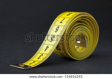 Yellow measure tape om black background