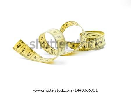 The yellow measuring centimetric tape curtailed by a spiral on a white background. Sewing accessories