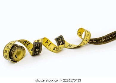 Yellow measuring tape isolated on white background. Tool for measuring length and volume. Yellow-black twisted tape for measuring in the clothing industry or the volume of the human body