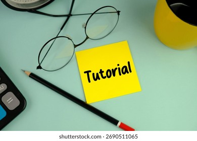 a yellow memo pad with words TUTORIAL as an education concept
