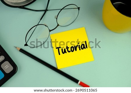 a yellow memo pad with words TUTORIAL as an education concept