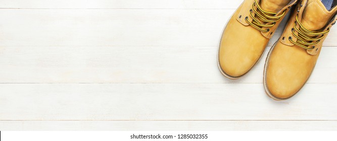 Yellow men's work boots from natural nubuck leather on wooden white background top view flat lay with copy space. Trendy casual shoes, youth style. Concept of advertising autumn winter shoes sale shop - Shutterstock ID 1285032355