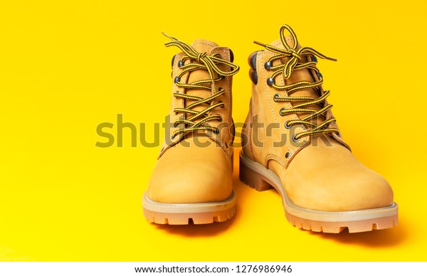 Yellow men\'s\
work boots from natural nubuck leather isolated on bright yellow\
background. Trendy casual shoes, youth style. Concept of\
advertising autumn winter shoes, sale,\
shop.