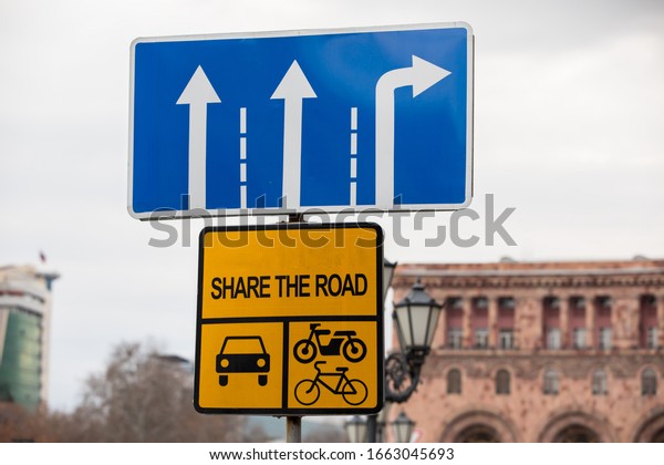 Yellow\
metal bicycle and car sign, share the\
road.\
