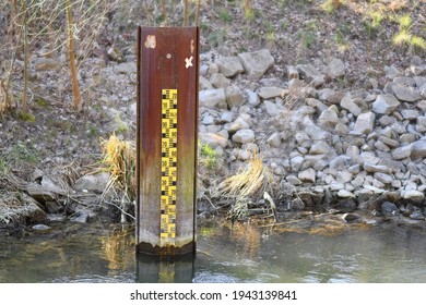 Yellow Metric Flood Level Marker In River With Low Water Level