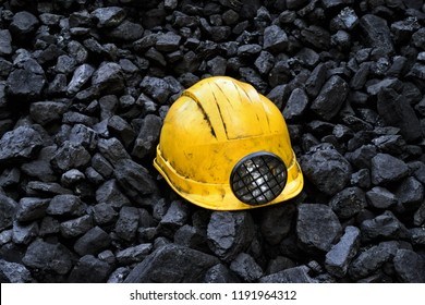 Yellow miners safety helmet on top of the coal mining