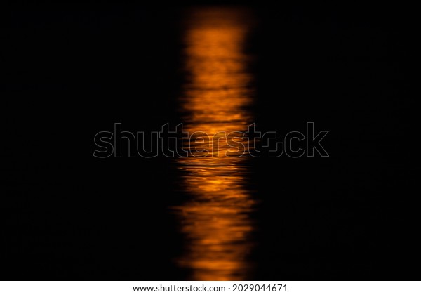 Yellow moon reflection in\
water