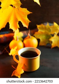 A Yellow Mug Of Hot Tea Or Coffee On A Wooden Table. Maple Branch With Yellow Leaves, Small Pumpkins. Thanksgiving Greeting Card