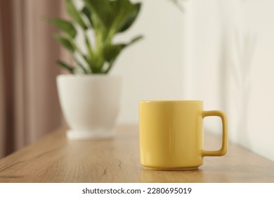 Yellow mug on wooden table indoors. Mockup for design - Powered by Shutterstock