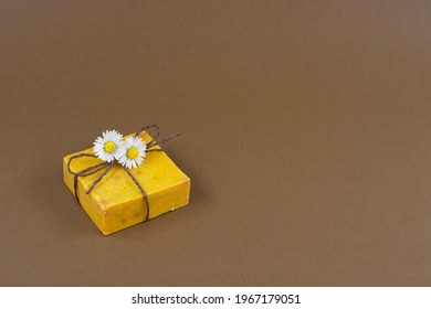 Yellow Natural Sulfur Soap And Daisies On A Brown Background