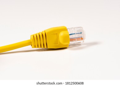 Yellow Network Cable with molded RJ45 plug isolated against white background.
