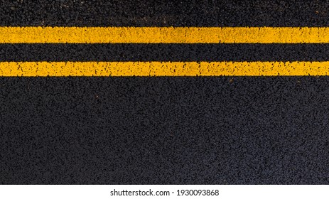 Yellow no parking lines on freshly laid tarmac road. - Shutterstock ID 1930093868
