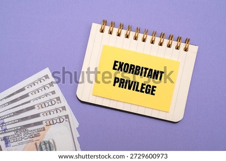A yellow note with EXORBITANT PRIVILEGE text and US dollar notes. Representing the global economic advantage of the United States dollar as a reserve currency