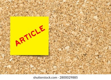 Yellow note paper with word article on cork board background with copy space