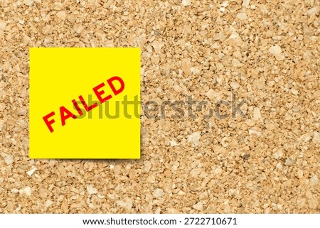 Yellow note paper with word failed on cork board background with copy space