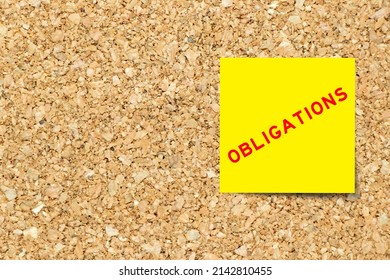 Yellow note paper with word obligations on cork board background with copy space - Shutterstock ID 2142810455