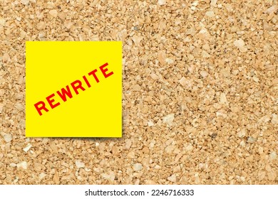 Yellow note paper with word rewrite on cork board background with copy space