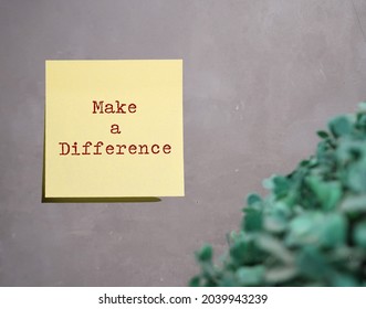 Yellow Note Stick On Gray Wall With Text Written MAKE A DIFFERENCE, Cocept Of Doing Things That Have Significant Impact Or Huge Positive Improvement To Society People Or Situation