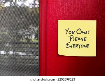 Yellow Note Stick On Red Wall With Handwritten Text You Can’t Please Everyone - Self Reminder To Stop Trying To Please Everyone And Be Your Authentic Self