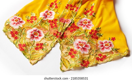 Yellow Nyonya Kebaya Cloth With Intricate Embroidery Of Red Flowers Isolated On White Background