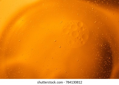 Yellow oil bubbles on water, cooking oil background.