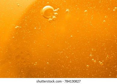Yellow oil bubbles on water, cooking oil background.