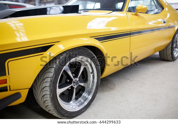 Yellow old muscle\
car with alloy wheel\
indoor.