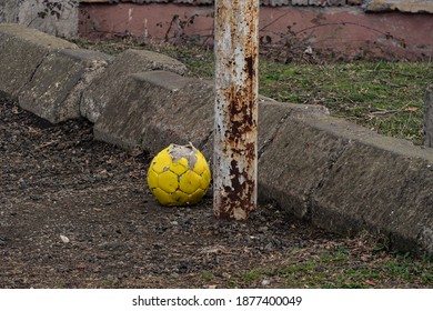 Yellow Old Soccer Ball Near The Goal Post