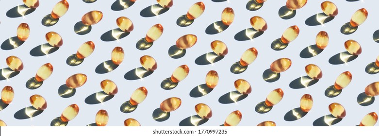 Yellow omega 3 capsule pattern. Different gold pills. Medical horizontal banner. Cosmetology wallpaper. Medicine vitamin. Grey background. Trend hard shadowss. Many isolated supplement
