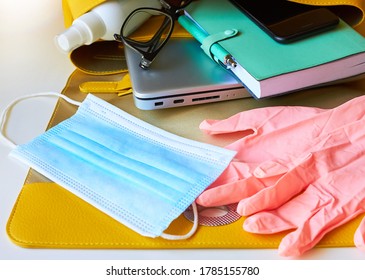 Yellow Open Ladies Bag Which Contains Disposable Pink Gloves, Mask, Antiseptic Spray, Glasses, Smartphone, Laptop, Notebook. Set For Returning To Work Or University