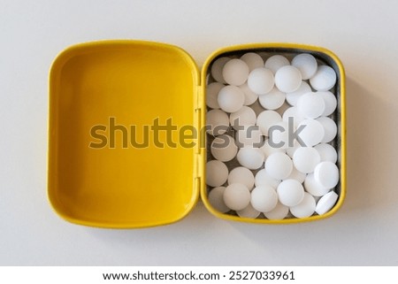 Yellow opened tin with mints.