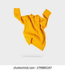 Yellow orange flying women's autumn knitted sweater on light gray background. Creative clothing concept, trendy fall winter cozy sweater pullover jersey. Women's fashion, autumn discounts. Shopping - Shutterstock ID 1798881247