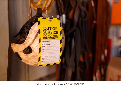 Yellow out of service tag attached on defect broken rope access safety helmet head fall protection do not use or operation construction mine site Perth, Australia