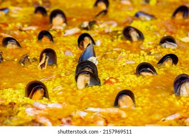 Yellow Paella Is A Traditional Spanish Dish Of Rice With Mussels In Seashells. Classic Spanish Paella With Seafood, Turmeric And Other Spices Wallpaper And Background. Cooking Street Food On Kitchen.