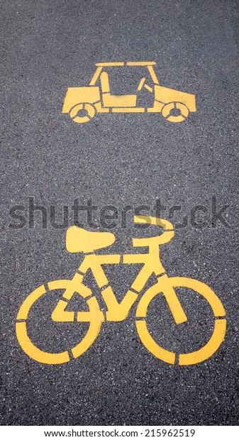yellow painted sign\
for bikes and car lane