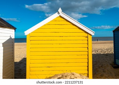 Yellow Painted Wooden Beach Hut Seen On A Sandy Beach On A Famous Beach Area In Suffolk, UK.