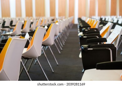 Yellow Paper Bags Placed On Empty Chairs Prepared For Participants Before Business Seminar In Modern Conference Center