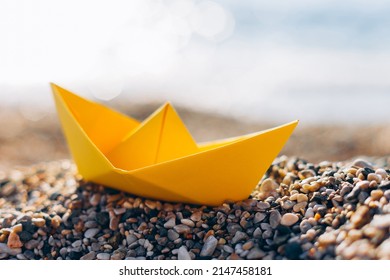 Yellow Paper Boat On The Pebble Beach